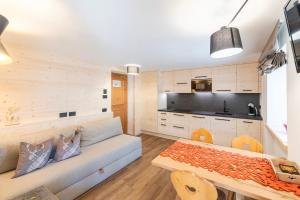 a living room with a couch and a table at Residence Bosco Verde in San Cassiano