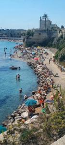 a beach with a bunch of people in the water at CASA ALTOMARE in Otranto