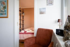 a living room with a chair and a bed at Prinz Hamlet Wohnung Pelzi 51 in Pelzerhaken +16 photos