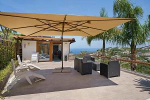 a patio with an umbrella and tables and chairs at Villa Panorama Isola di Ischia in Casamicciola Terme