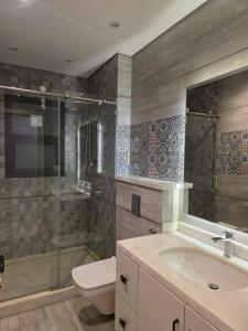 a bathroom with a toilet and a sink and a shower at وحده فندقيه خمس نجوم ويست تاون بفرلي هيلز سوديك الشيخ زايد in Kafr Abū ʼumaydah +26 photos