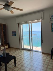 a living room with a ceiling fan and a view of the ocean at Casa sul mare in Vibo Valentia Marina