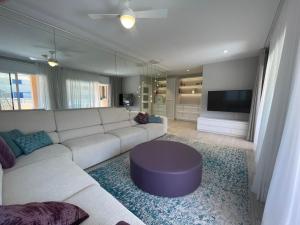 a living room with a white couch and a tv at S'agaró Mar in Sant Feliu de Guíxols +9 photos