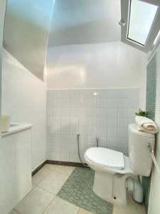 Un baño blanco con inodoro y ventana. en Carthage vacation Home, en Túnez