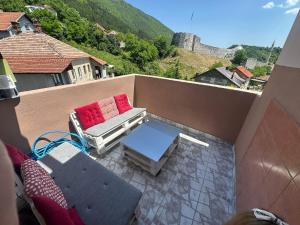 a balcony with a couch and a table on a balcony at Stan Travnik in Travnik