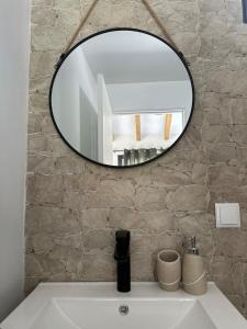 ein Badezimmer mit einem Spiegel über einem weißen Waschbecken in der Unterkunft The Green Valley House II in São Vicente + 51 Fotos