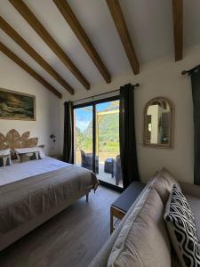 ein Schlafzimmer mit einem Bett und einem großen Fenster in der Unterkunft The Green Valley House II in São Vicente