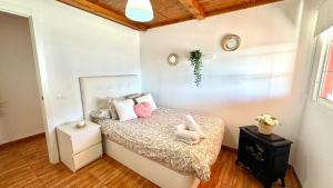 Un dormitorio con una cama con almohadas rosas. en Joha's Zen, en Islas Canarias