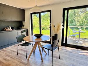 a kitchen and dining room with a table and chairs at Kingfisher - Luxurious Off-Grid Eco Cabin with Riverviews in Market Drayton +27 photos