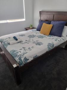 a bed with blue and white sheets and pillows at La Luna House in Logan Village