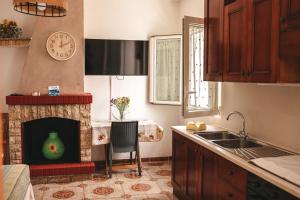a kitchen with a fireplace with a clock on the wall at VILLA ALFONSINA in Uggiano la Chiesa +37 photos