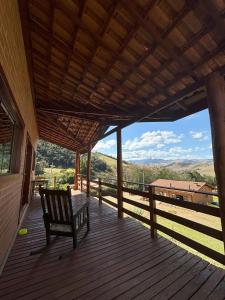 a wooden porch with a bench on a deck at La Maison De Bonneval in São Bento do Sapucaí