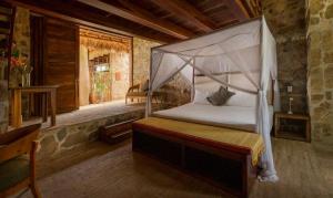 a bedroom with a bed with a canopy at Villa Aurema a Quiet Nature Retreat in Santa María Tonameca