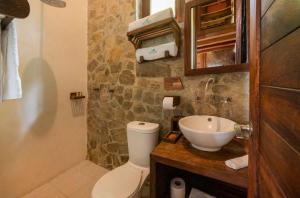a bathroom with a white toilet and a sink at Villa Aurema a Quiet Nature Retreat in Santa María Tonameca