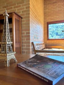 a book on a table with a model of the eiffel tower at La Maison De Bonneval in São Bento do Sapucaí