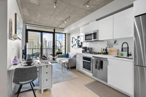 Una cocina con gabinetes blancos y una sala de estar. en MicroNest - Modern Overlooking Downtown Parking, en Calgary