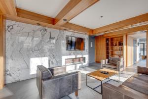 Una sala de estar con una pared de piedra con chimenea. en MicroNest - Modern Overlooking Downtown Parking, en Calgary