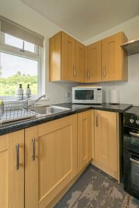 a kitchen with a sink and a microwave at Oak Cabin Overlooking Bedgebury Forest in Goudhurst