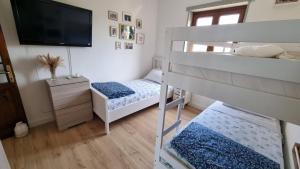 a bedroom with two bunk beds and a flat screen tv at Casa al mare con vista sull asinara in Sorso