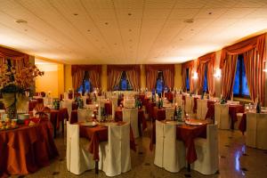 una stanza piena di tavoli con tovaglie bianche e rosse di Hotel Diana a Boario Terme