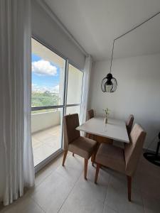 a dining room with a table and chairs and a window at Cobertura em Condominio no Planalto in Manaus