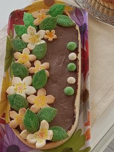 Un pastel de chocolate con flores y hojas sobre una mesa. en DOMUS ULIVI LUXURY ROOMS Moresca, en Catania