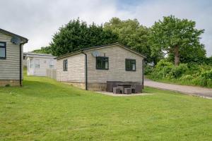 a house with a picnic table in a yard at Oak Cabin Overlooking Bedgebury Forest in Goudhurst