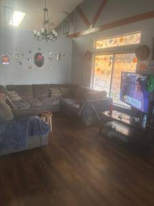 a living room with a couch and a tv at Master bedroom in Bakersfield