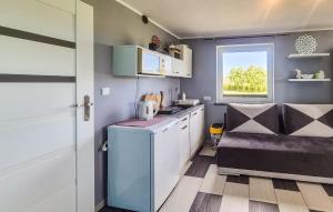 a small kitchen with white cabinets and a window at Awesome Apartment In Zastan With Wifi in Zastań