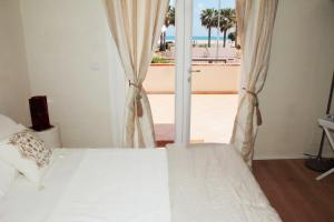 een slaapkamer met een bed en uitzicht op de oceaan bij Suite Faro 33 in San Vito lo Capo