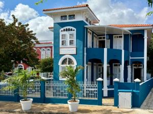 una casa azul con una valla blanca en Villa Amalie & Villa Curiel, en Willemstad