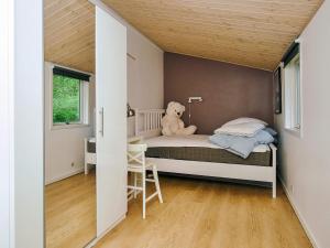 a teddy bear sitting on a bed in a room at 8 person holiday home in Holbæk in Holbæk