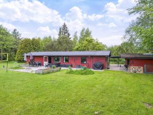 a red house with a yard in front of it at 8 person holiday home in Holbæk in Holbæk