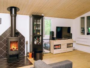 a living room with a fireplace and a tv at 8 person holiday home in Holbæk in Holbæk