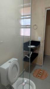 a bathroom with a white toilet and a piano at Linda casa Edícula "fundos do terreno" com piscina in Itanhaém +40 photos