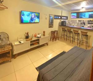 a living room with a tv on the wall at Casa inteira Ilha Grande in Abraão