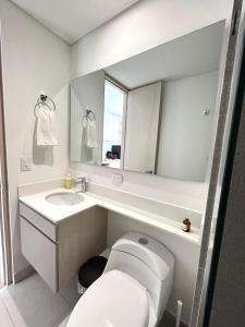 une salle de bain avec toilettes, lavabo et miroir dans l'établissement Cozy New Loft Coworking Gym Terrace Play Z, à Bogotá