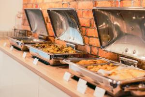 Un buffet con varias bandejas de comida en un mostrador. en Boho Łeba z basenem krytym i jacuzzi, en Łeba 6 fotos más