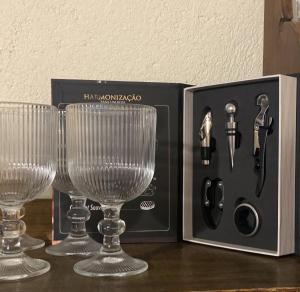 two wine glasses and a knife kit on a table at Casa inteira Ilha Grande in Abraão