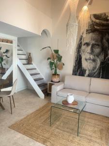 a living room with a white couch and a staircase at Les Jardins du Soleil in Vic-la-Gardiole