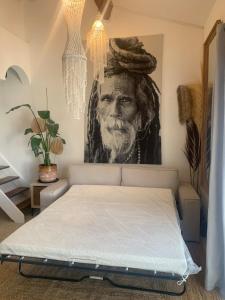 a bed in a room with a painting of a man at Les Jardins du Soleil in Vic-la-Gardiole