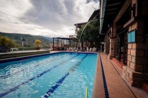 a swimming pool in front of a building at Hotel Plaza Menor in Santa Fe de Antioquia