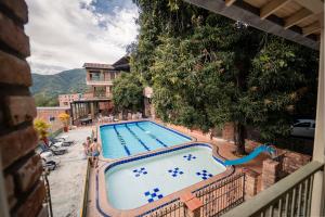 a large swimming pool with people standing around it at Hotel Plaza Menor in Santa Fe de Antioquia