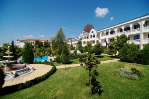 un gran edificio blanco con un jardín y una fuente en SOUTH BEACH Apart Complex en Sveti Vlas