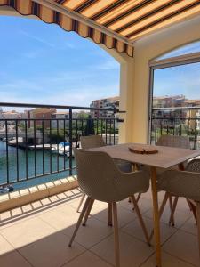 a balcony with a table and chairs and a view of the water at loft appartement in Cap d'Agde