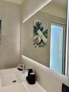 a white bathroom with a sink and a mirror at Settanni Suites in Polignano a Mare