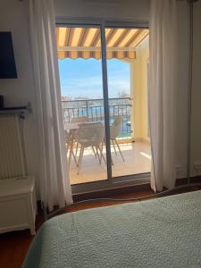 a bedroom with a bed and a balcony with a table at loft appartement in Cap d'Agde +51 photos