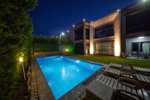 a swimming pool in front of a house at night at Andalus Villas NO ALCOHOL ALLOWED with Heated Pool in Sapanca
