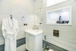 Un baño blanco con lavabo y espejo. en Park Azure One Bedroom Luxury Apartment, en Baku 22 fotos más