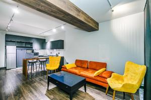 Una sala de estar con un sofá y sillas y una cocina. en Park Azure One Bedroom Luxury Apartment, en Baku
